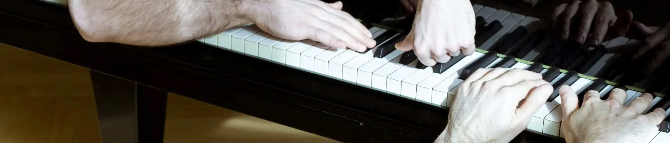 Ribbon AMBO, hands form Hannes Taljaard and Aleksandr Okhotnikov on a piano keyboard